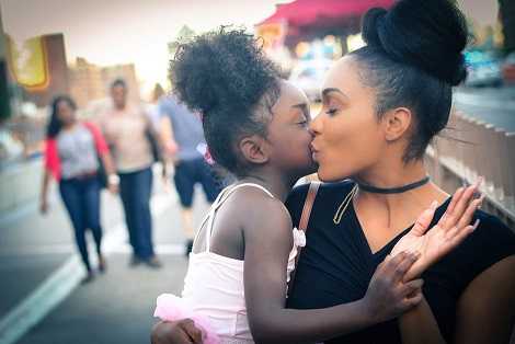 A single mom is kissing her baby